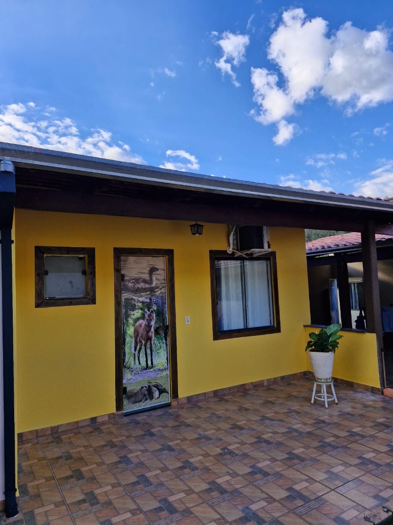 Fachada com porta decorada com fauna brasileira na Pousada Essência da Canastra