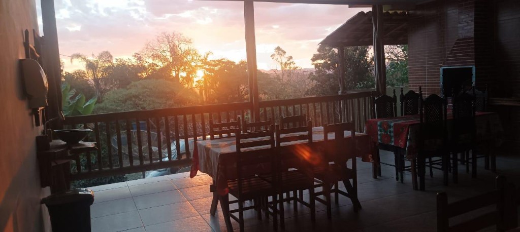 Varanda da Pousada Dona Lourdes com vista para a serra ao pôr do sol