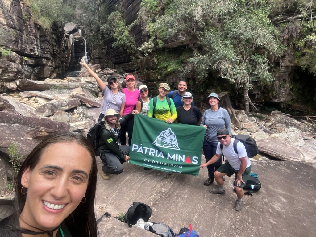 Grupo com a bandeira Pátria Minas na cachoeira