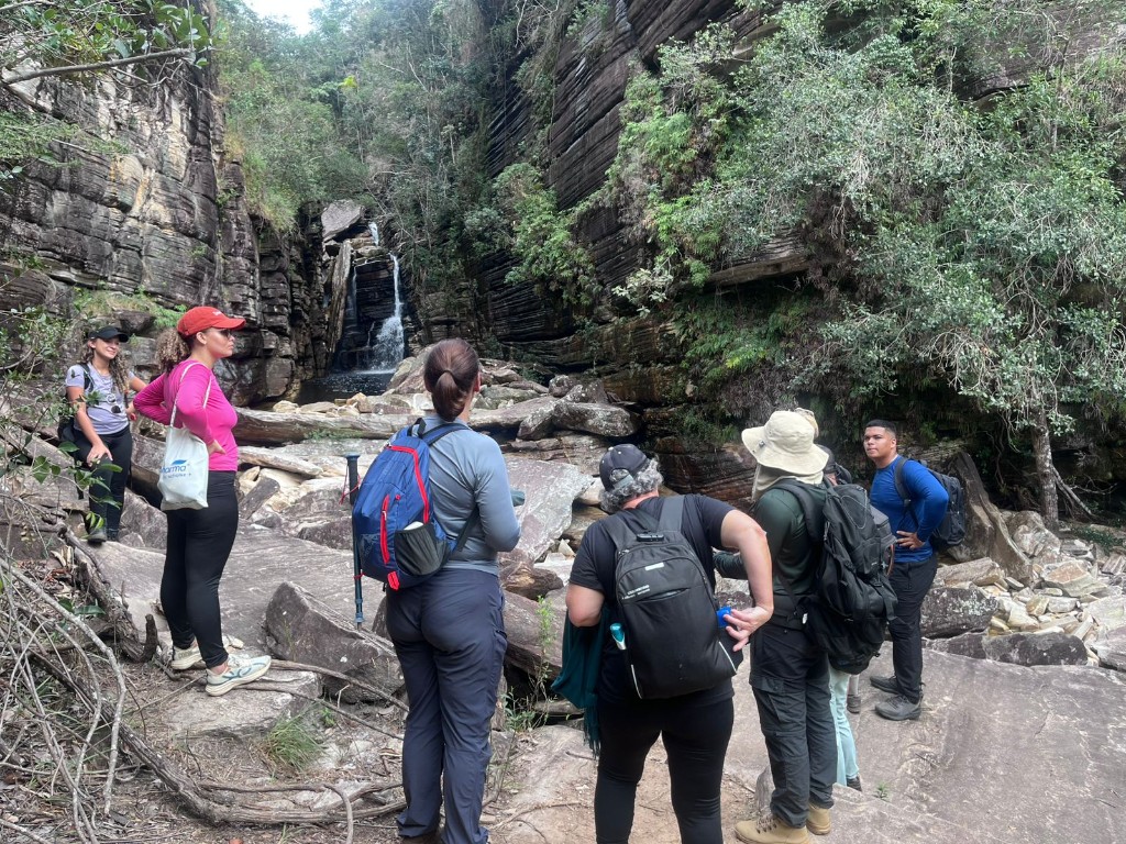 Grupo em trilha no cânion com cachoeira